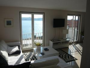 a living room with a couch and a view of the ocean at G&B Apartments in Trogir
