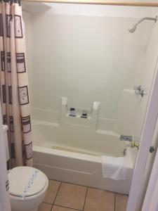 a bathroom with a white tub and a toilet at Rivers Inn in Fort Madison +61 photos