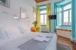 sypialnia z łóżkiem z ręcznikami w obiekcie C&O Guest House Lisbon w Lizbonie