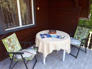 バラトンマーリアフュルドゥーにあるVitorlás Nyaralóházの本を置くポーチのテーブルと椅子