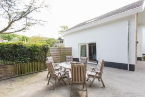 een patio met een tafel en stoelen in een tuin bij Villa Zeezout I Kloeg Collection in Zoutelande