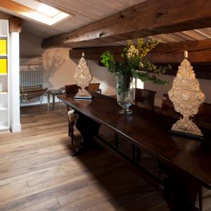 a dining room with a wooden table with vases on it at M Club De Luxe B&B in Ravenna