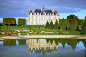 a castle with its reflection in the water of a garden at Le Parisien T1Antony-Berny by Beds4Wanderlust - 35m2 avec Balcon - Aéroport Orly 5miles - Train Station RER B ORLYVAL 1mile in Antony