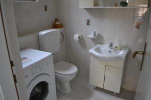 a bathroom with a white toilet and a sink at Alex in Rijeka