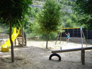 a child playing on a swing set in a playground at VUT Vivienda de uso turístico la Risca in Molinos de Papel