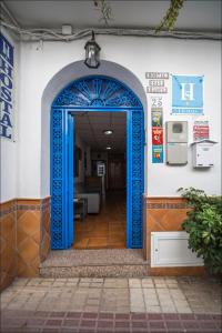 Hostal San Ramón في مربلة: مدخل لمبنى بمدخل ازرق