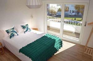 a bedroom with a large bed and a large window at Alojamento Charme in Bombarral