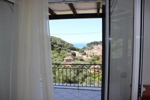 a room with a balcony with a view of the ocean at Residence La Scala in Parga