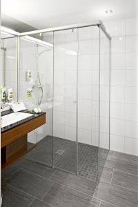 W łazience znajduje się szklana kabina prysznicowa i umywalka. w obiekcie MT Hotel w mieście Zeltweg