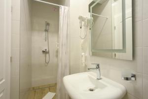 a white bathroom with a sink and a shower at Villa Prestige in Mostar