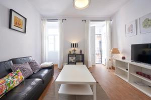 リスボンにあるT3 in Casa da Mariquinhas (3 bedroom flat)のリビングルーム(黒い革張りのソファ、白いテーブル付)