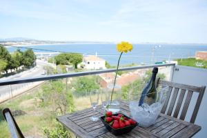 a table with a flower and a bottle of wine and strawberries at Apartamentos Pinhão in Lagos