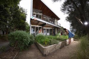 a person standing in front of a house at Apollo Bay Eco YHA in Apollo Bay