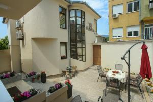 a patio with a table and chairs in front of a building at Villa Prestige in Mostar