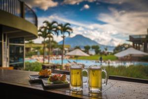 a table with two glasses of beer and a plate of food at Porta Hotel del Lago in Panajachel