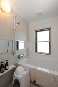 a bathroom with a tub and a toilet and a window at Hotel Sunriver Shimanto in Shimanto +37 photos