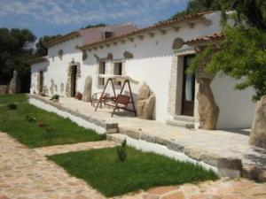 Casa blanca con patio con columpio en B&B L' Incantu, en Santa Teresa Gallura
