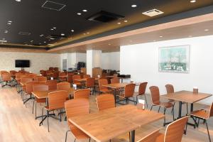 a room with wooden tables and chairs and a screen at Hotel Sunriver Shimanto in Shimanto