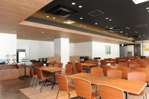 a restaurant with wooden tables and chairs at Hotel Sunriver Shimanto in Shimanto