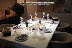 a table with a white table cloth and wine glasses at Luxury 3 Bedroom Penthouse With Private Garage in Braga
