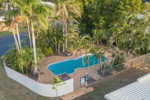 een uitzicht over een zwembad met palmbomen bij Moore Park Beach Inn in North Coast