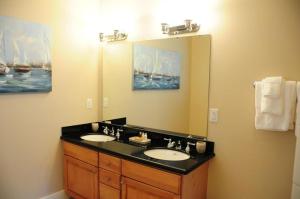a bathroom with two sinks and a large mirror at Anglers Reef Getaway in Islamorada