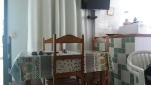 a table with two chairs and a table with a cloth on it at Condomínio Taperapuã Praia Village in Porto Seguro