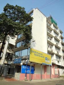 Um edifício alto com um sinal amarelo à frente. em Royal Park Hotel Dockyard em Mumbai