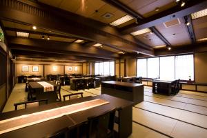 a dining room with tables and chairs and windows at Onyado Tsutaya in Kiso