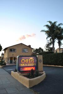 uma estalagem oásis e suites assinam em frente a um edifício em Oasis Inn and Suites em Santa Bárbara