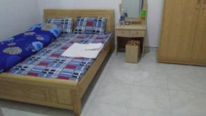 ein Schlafzimmer mit einem Bett und einer Kommode in einem Zimmer in der Unterkunft Nhà Nghỉ Hạnh Phúc in Mộc Châu