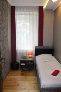 a small bedroom with a bed and a window at Homestay Lela and Mari in Kazbegi