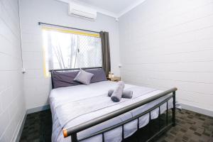 
a bedroom with a white bed and white walls at Mad Monkey Backpackers Village in Cairns
