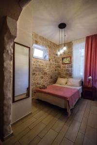a bedroom with a large bed with a pink blanket at Apartments Mia in Dubrovnik