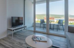 salon z kanapą, telewizorem i stołem w obiekcie Sun & Sea Villa w Krku