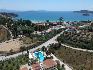 an aerial view of a resort with a pool and the ocean at Meraki Apartments and Studios in Tolo