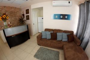 sala de estar con sofá marrón y TV en Hostal Gemar, en Panamá