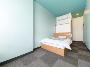 a bedroom with a bed and a wall at Business Hotel New Nagawajima in Fukuyama