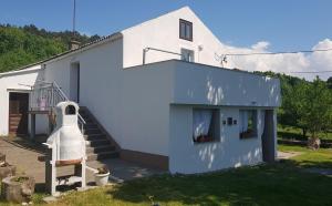 a white house with a staircase next to it at Apartman Duba in Senj