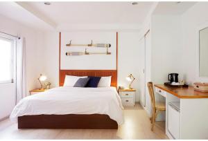 Habitación blanca con cama y escritorio en Malibu Koh Samui Resort & Beach Club - SHA Extra Plus, en Chaweng