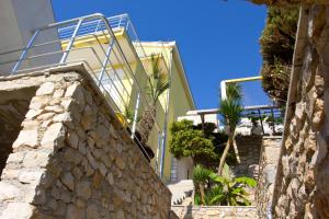 a building with stairs and palm trees in front of it at Apartments Gran Sasso in Ulcinj