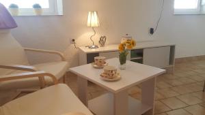 a living room with a table with cups and flowers on it at Apartman Duba in Senj