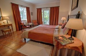 a bedroom with a bed and a table with a lamp at Golden Hill Guest House in Somerset West
