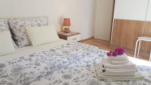 a bedroom with a bed with a pile of towels at Apartman Duba in Senj