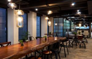 a large table in a room with chairs and lights at S Loft Manado in Manado