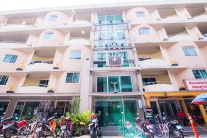 a large building with bikes parked in front of it at Mosaik Apartment in Pattaya South