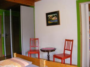 Duas cadeiras vermelhas e uma mesa num quarto em Appartementhaus Schwarzwaldblick em Lauterbach