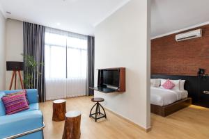 a living room with a blue couch and a bed at S Loft Manado in Manado