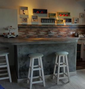 a bar with two stools and a counter top at Villa Lumbalumba in Lovina