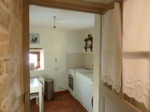 a small kitchen with a sink and a table at Le Logis d'Hortense in Vic-le-Comte